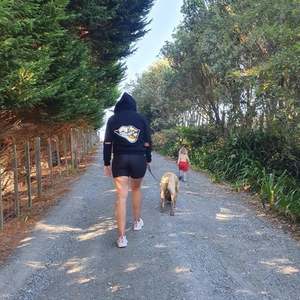 Ngahuia walks the dog in our Gold Lips Sequin hoodie in Whangarei