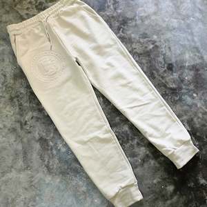 New Arrivals: Monogram Embossed Trackpants - Stone