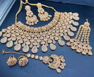 Bridal Necklaces Semi Bridal Necklaces: (video clip attached)Golden color Beautiful and elegant look meenakari &original polki stones with pearls studded very Heavy work necklace with beautiful bigger size earrings and Tikka Note :- original Polki stones not fake plastic stones)