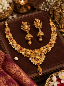 Jewellery: Elegant matte gold-finish Temple Jewellery Set featuring an intricate Radha Krishna motif with beautifully detailed elephant designs and Ruby stone accents. Comes with matching jhumka earrings(slight variation in color & design may occur)