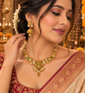 Jewellery: Elegant matte gold-finish Temple Jewellery Set Goddess Lakshmi motif with beautifully detailed elephant designs and green ,Ruby stone accents. Comes with matching jhumka earrings(slight variation in color & design may occur)