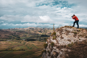 Products: A Photographer stood at the top of Te Mata Peak photographing the Tukituki valley, Hawke's Bay, New Zealand - SCP Stock