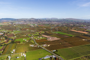 Products: Aerial view looking over rural land towards Havelock North, with the three peaks in the distance, Hastings, Hawke's Bay, New Zealand - SCP Stock