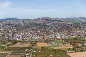 Aerial view looking over rural land towards Havelock North, with the three peaks&hellip;